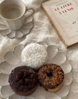 Rinka Mug and matching porcelain plate with donuts and a book on a textured cloth background.