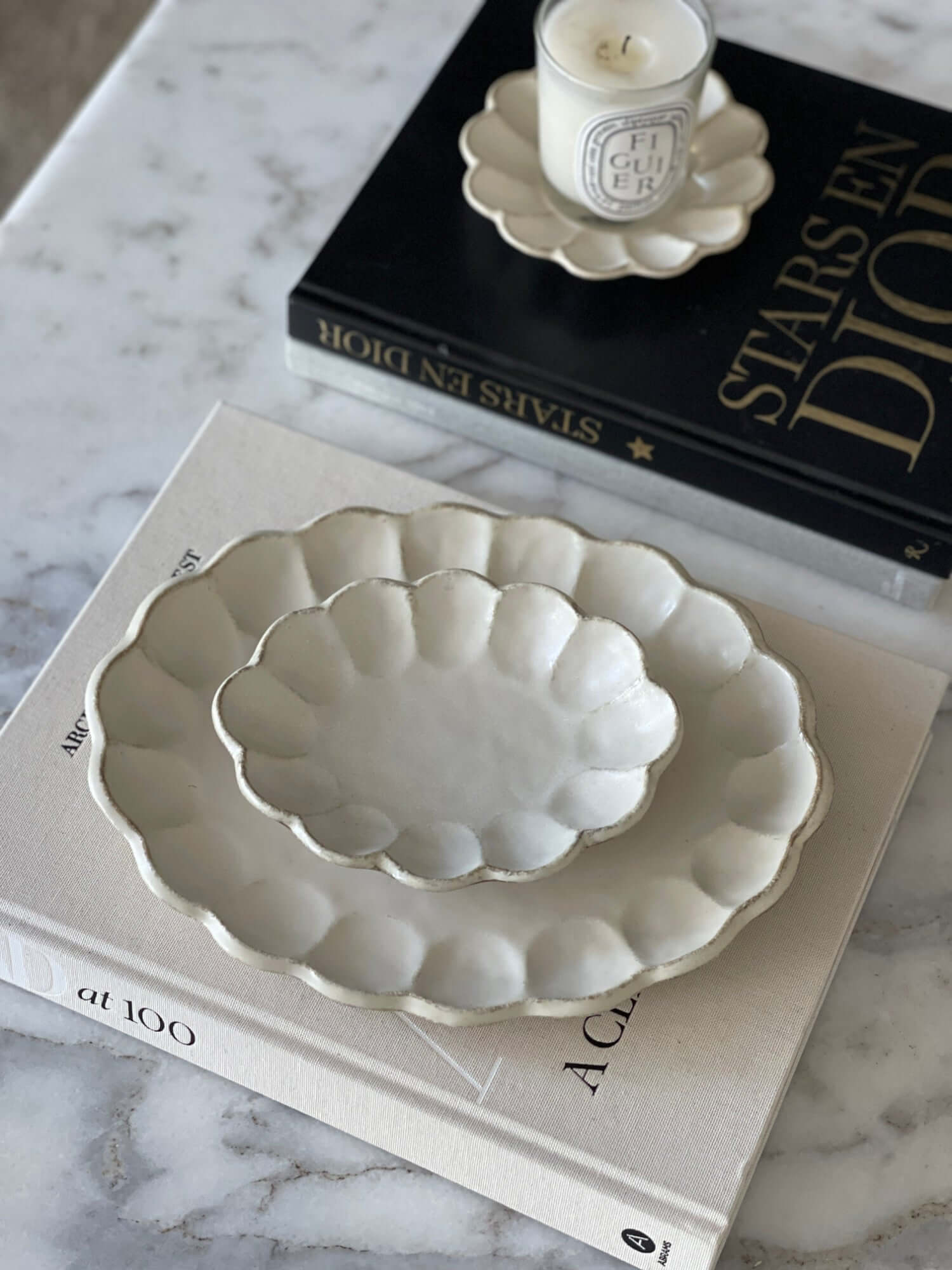 Elegant Rinka Oval Plates made of porcelain, styled on marble table with books and candle, perfect for enhancing table settings.