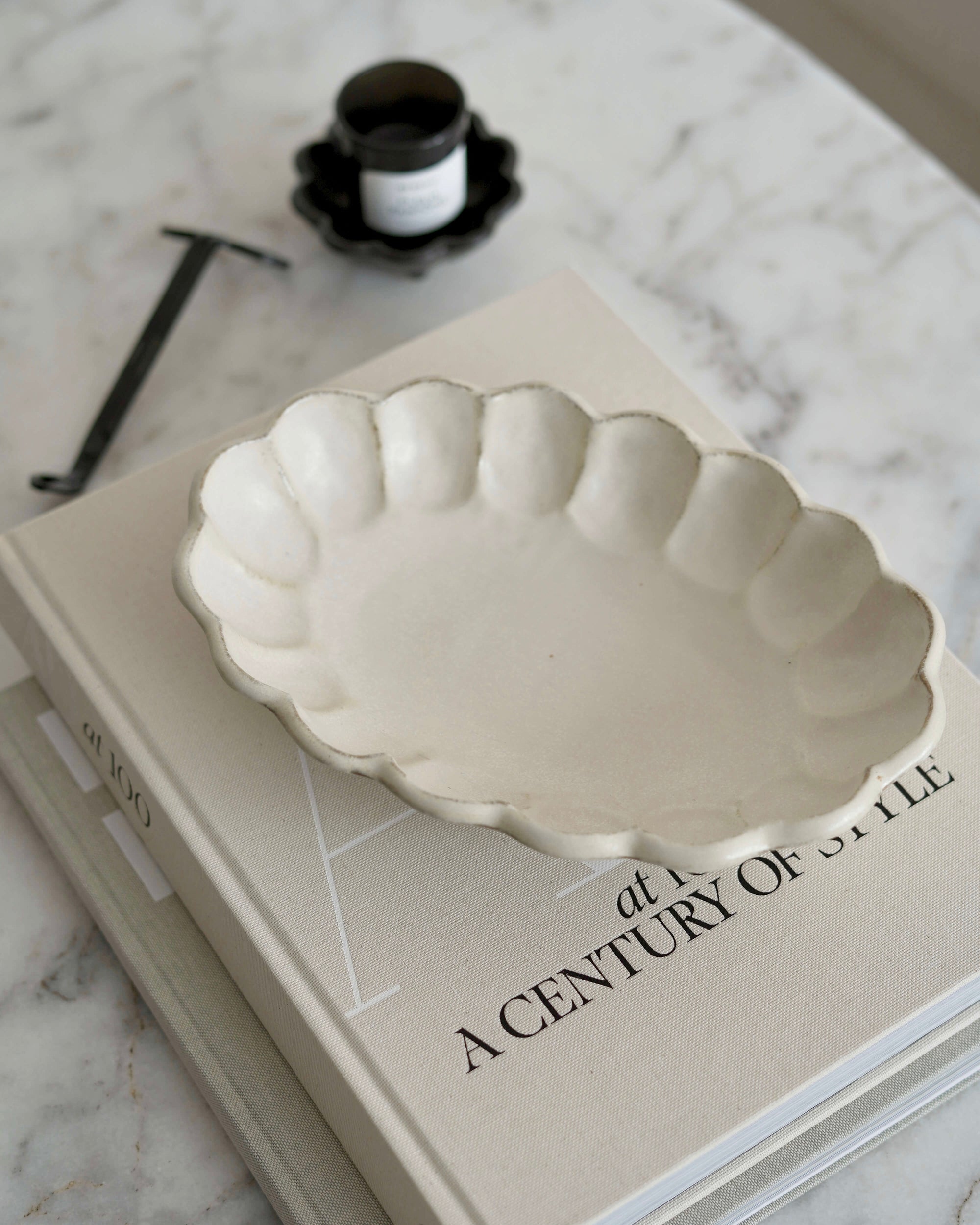 Rinka Oval Bowl 28cm in porcelain, showcasing a delicate flower shape, on a tabletop with décor items, part of the Kaneko Kohyo collection.