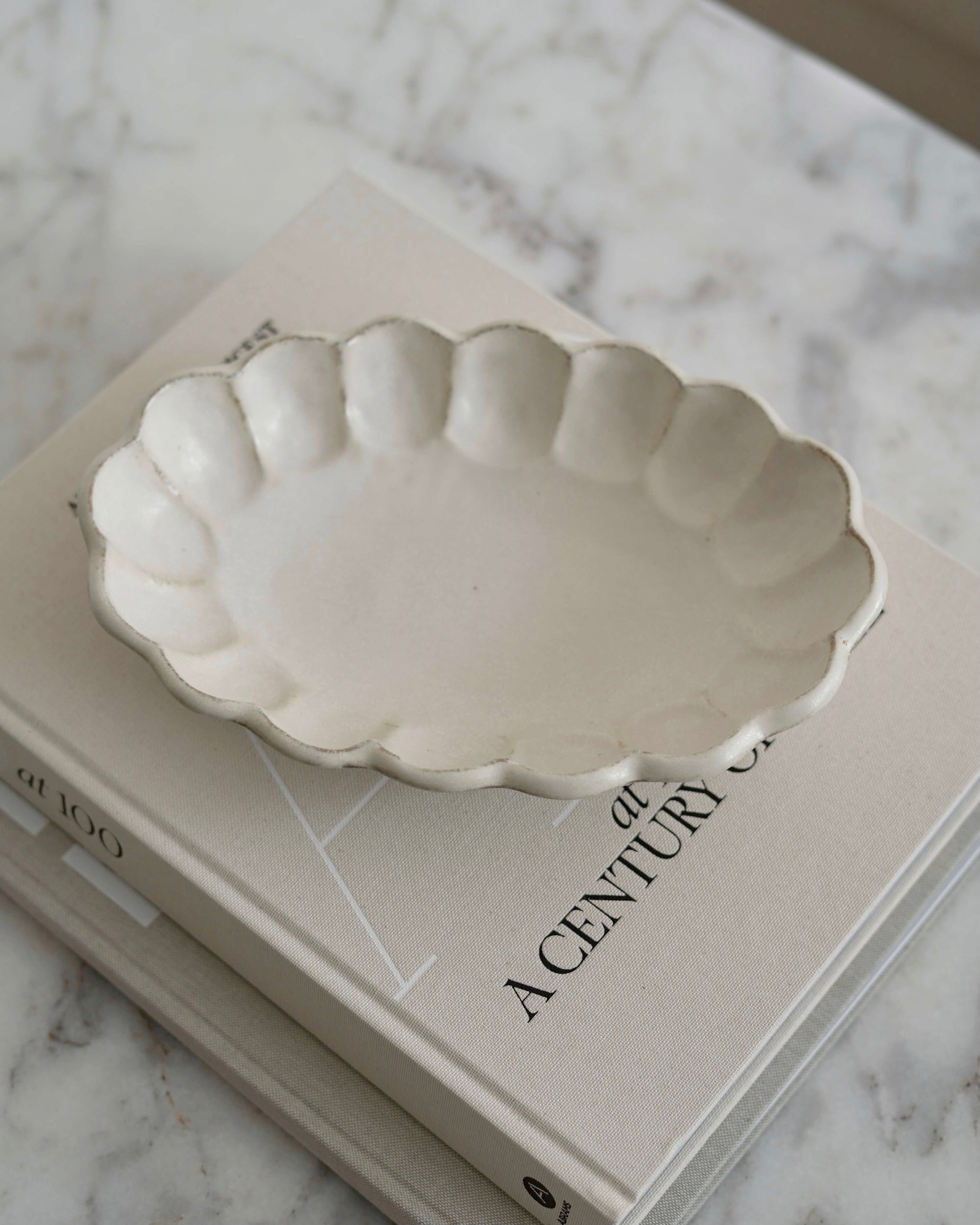 Porcelain Rinka Oval Bowl 28cm with flower shape on book, part of Kaneko Kohyo's handcrafted collection, Japan's delicate tableware.