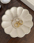 Beige Rinka Plate by Kaneko Kohyo showcasing jewelry, handmade in Japan, microwave and dishwasher safe, decorative display.