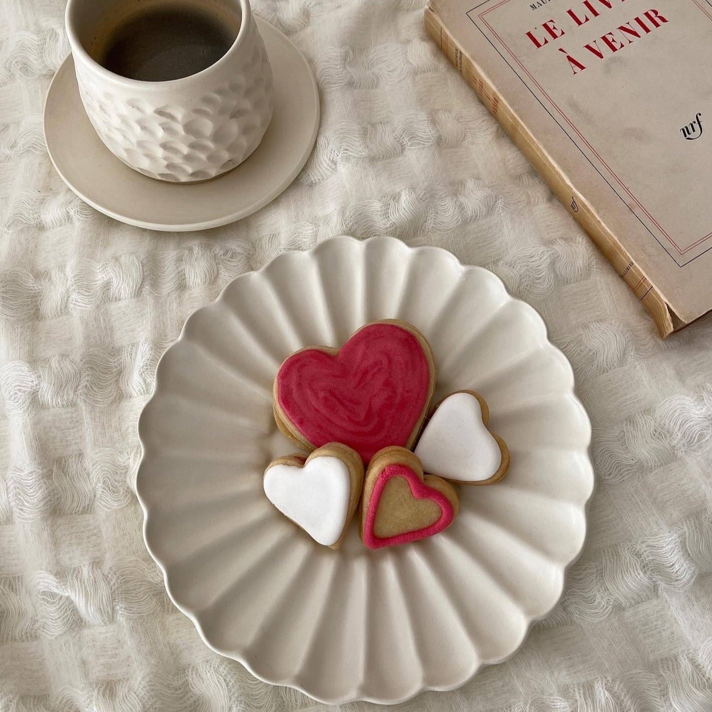 Elegant Rinka Plate by Yoshida Pottery displaying heart-shaped cookies, enhancing a cozy table setting with tea and a book.