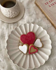 Elegant Rinka Plate by Yoshida Pottery displaying heart-shaped cookies, enhancing a cozy table setting with tea and a book.