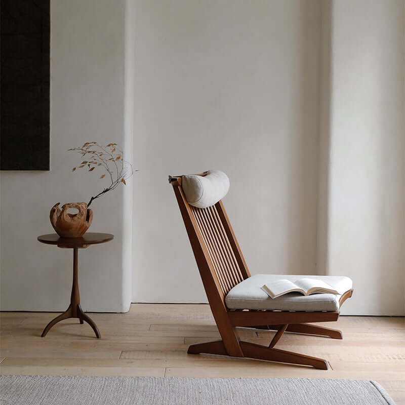 Nakajima George reclining chair made of teak wood and rattan, with open book, adding elegance and a romantic vibe to the room.