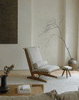 Nakajima George reclining chair in serene room, showcasing elegant design with teak wood and rattan weave, enhancing romantic ambiance.