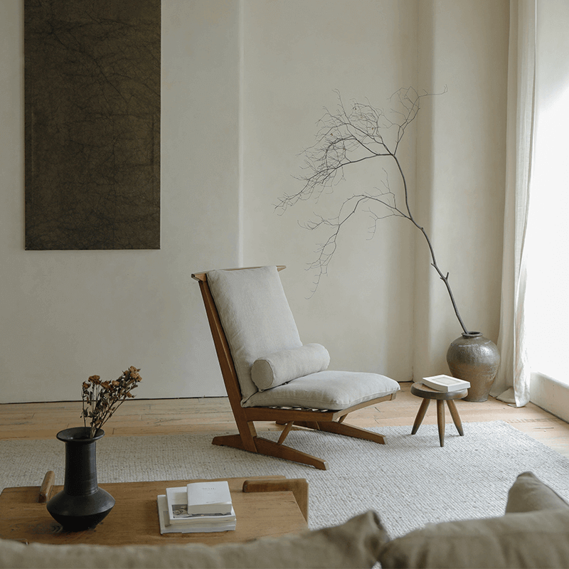 Nakajima George reclining chair in serene room, showcasing elegant design with teak wood and rattan weave, enhancing romantic ambiance.