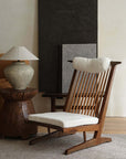 Nakajima George Reclining Chair in teak wood with rattan weaving, natural linen cushion, and romantic design in a cozy room setting.