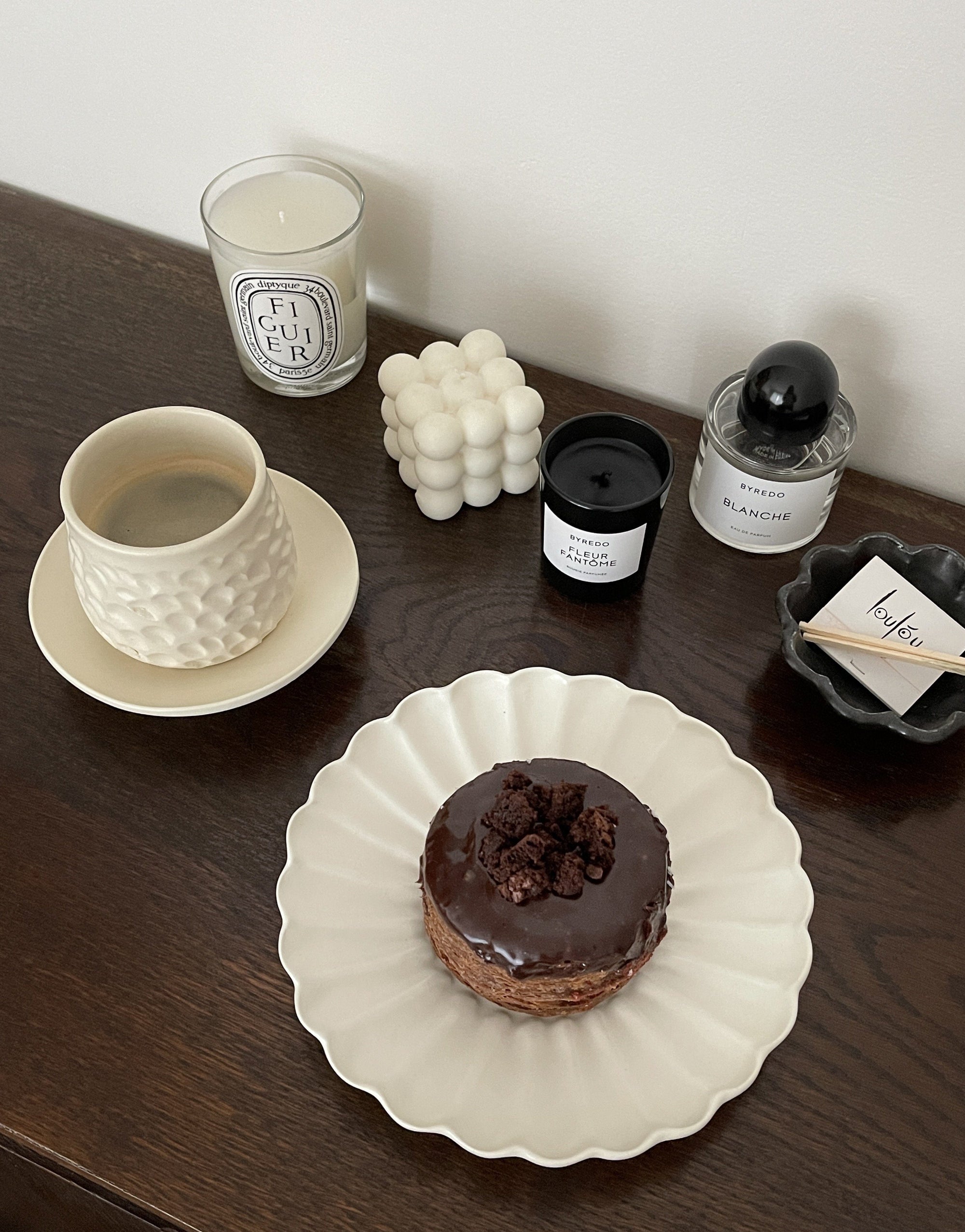 Shinogi Cup and Saucer Set with nature-inspired design, displayed on a wooden table with a chocolate donut on a plate nearby.