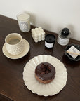 Shinogi Cup and Saucer Set with nature-inspired design, displayed on a wooden table with a chocolate donut on a plate nearby.