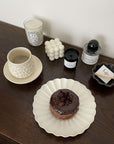 Shinogi Cup and Saucer Set with nature-inspired design, displayed on a wooden table with a chocolate donut on a plate nearby.