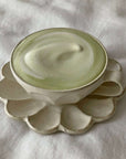 Porcelain flower-shaped soup cup set from Rinka Collection on white fabric background.