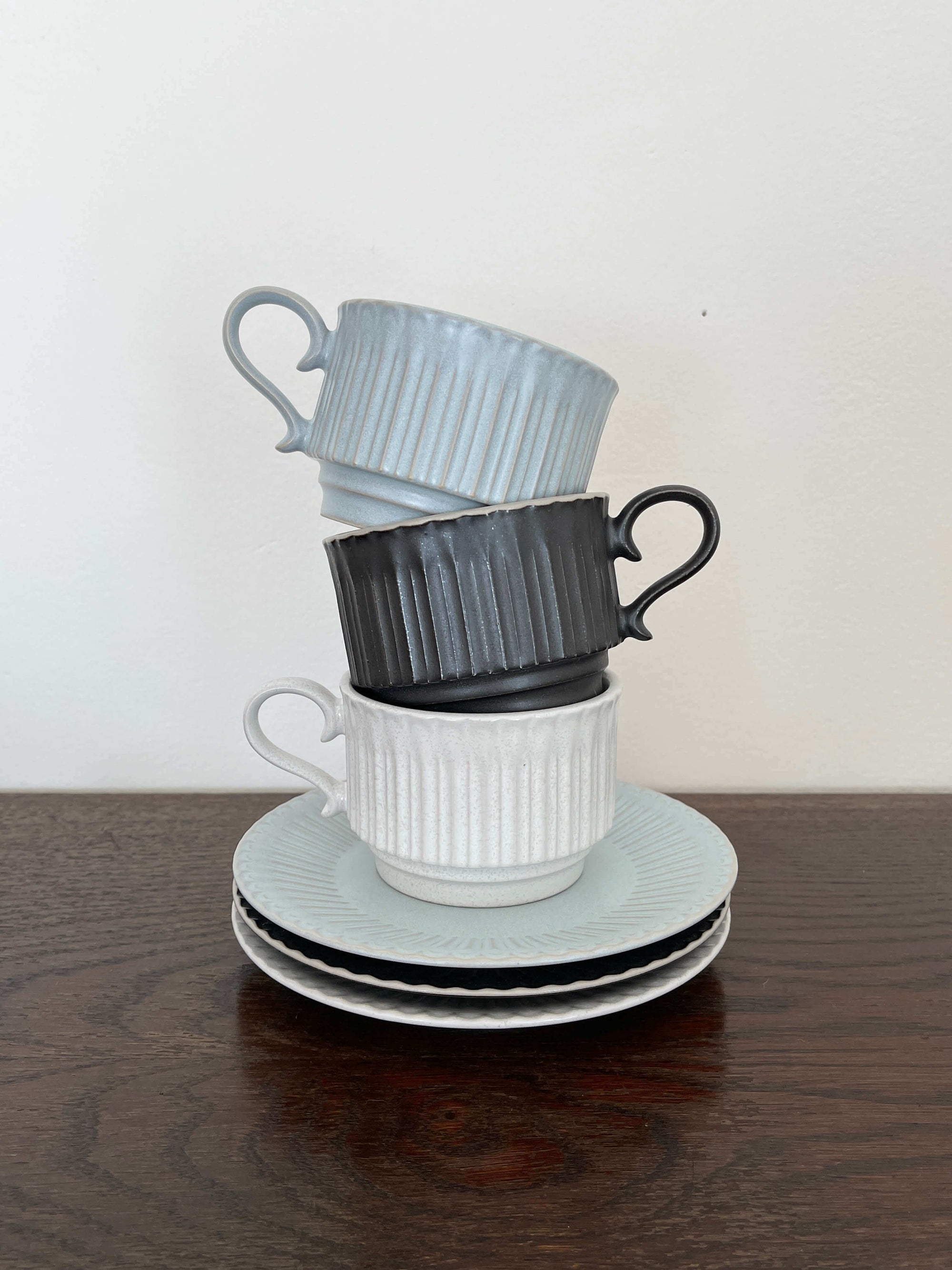 Elegant Storia coffee cups and saucers inspired by antique European design, featuring a soft lace form and lacquer finish.
