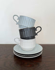 Elegant Storia coffee cups and saucers inspired by antique European design, featuring a soft lace form and lacquer finish.
