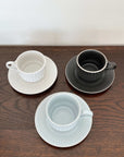 Three Storia coffee cups and saucers with European design on a wooden surface, featuring flecked lacquer finish from Koyo, Japan.