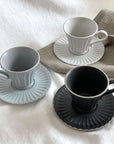 Storia Tall Coffee Cup & Saucer set in porcelain, showcasing elegant flecked lacquer finish in three colors on a soft table setting.