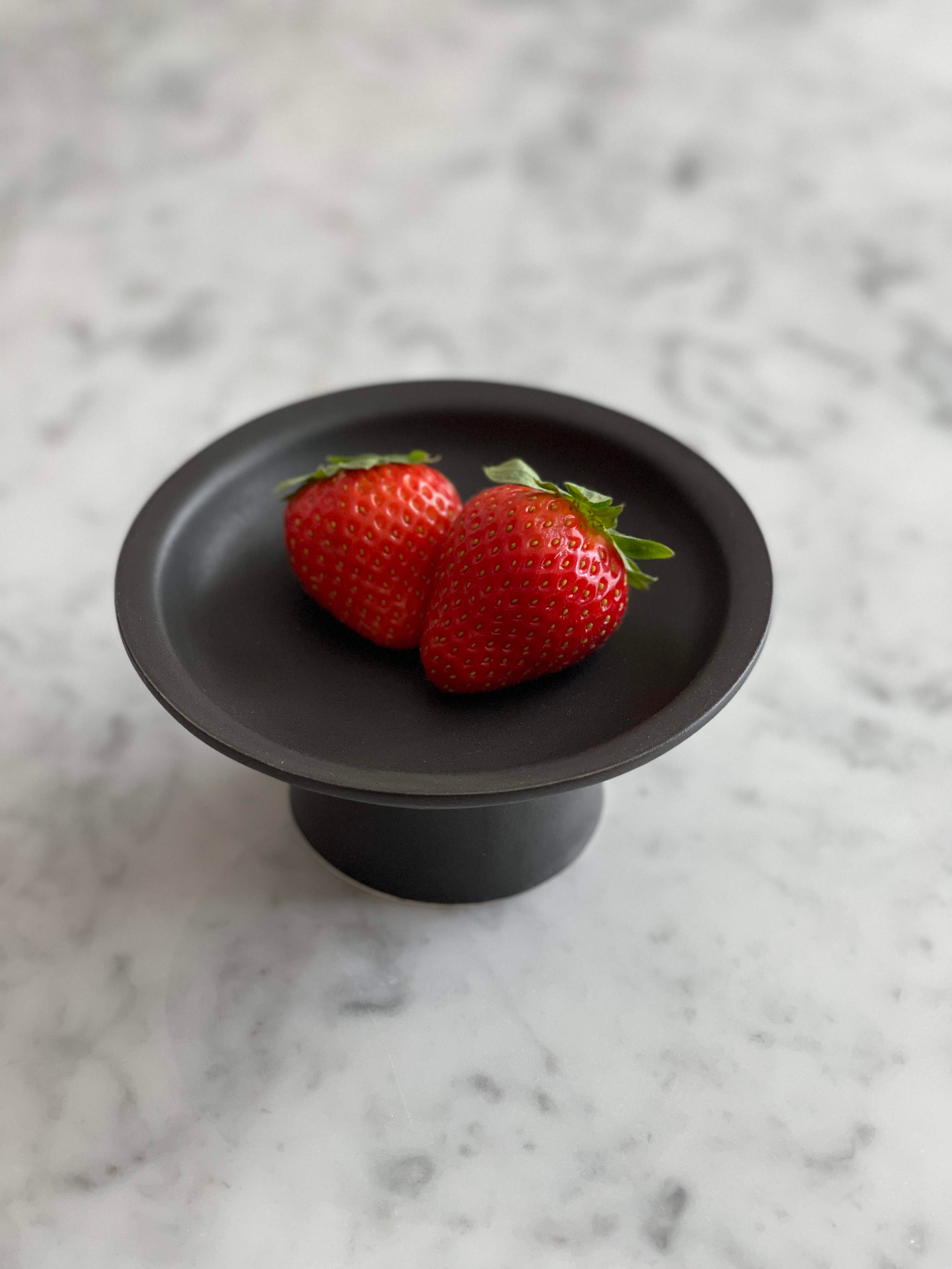 Black Tall Plate by Yoshida Pottery with strawberries on marble surface