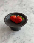 Black Tall Plate by Yoshida Pottery with strawberries on marble surface