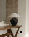 Wabi-Sabi style handmade table lamp with milky white and black body, linen lampshade, creating a peaceful and artistic atmosphere