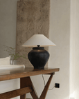 Wabi-Sabi style handmade table lamp with milky white and black body, linen lampshade, creating a peaceful and artistic atmosphere