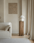 Wabi-Sabi style handmade table lamp with milky white pottery base and linen shade, set in a serene living room with natural decor.
