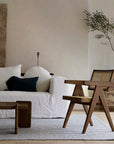 Chandigarh chair with antique wabi-sabi design, crafted from African teak and rattan, complements minimalist living room décor.