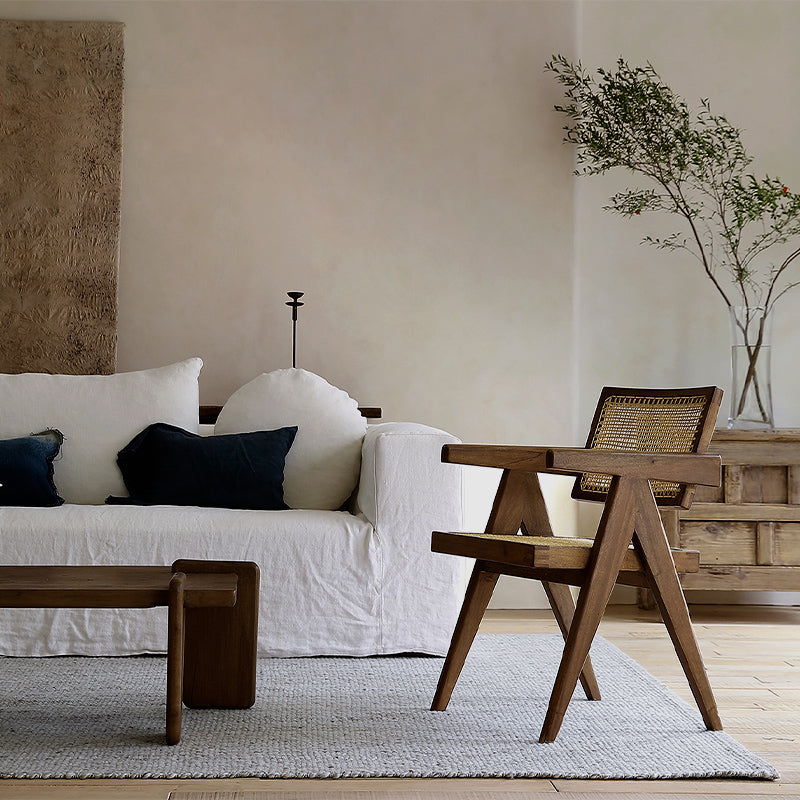 Chandigarh chair with antique wabi-sabi design, crafted from African teak and rattan, complements minimalist living room décor.