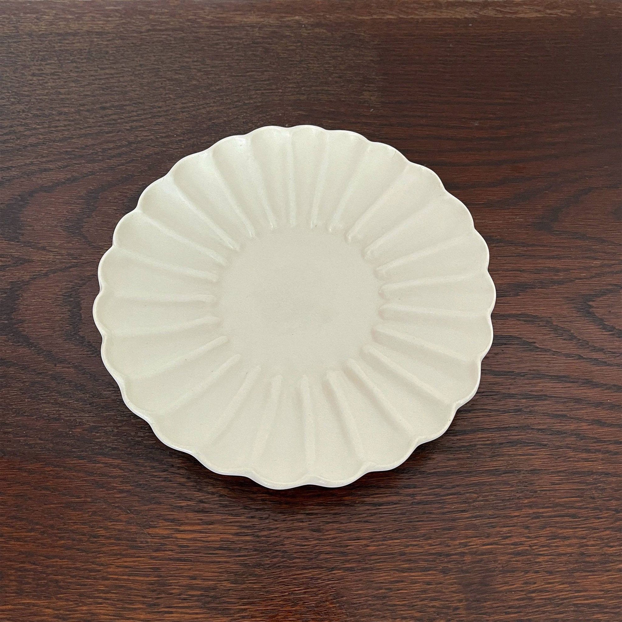 Elegant Rinka Plate by Yoshida Pottery with nature-inspired design on a wooden table. Perfect for enhancing table settings.