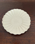 Elegant Rinka Plate by Yoshida Pottery with nature-inspired design on a wooden table. Perfect for enhancing table settings.