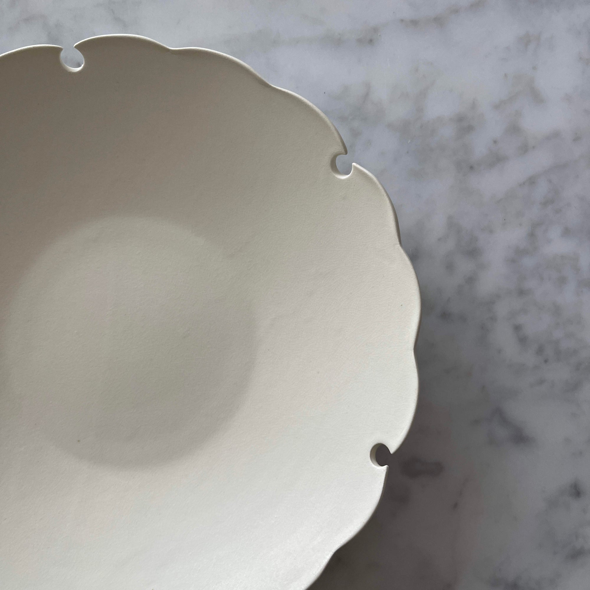 Elegant Yukiwa Plate by Yoshida Pottery with nature-inspired design, showcasing unique scalloped edges on a marble background.