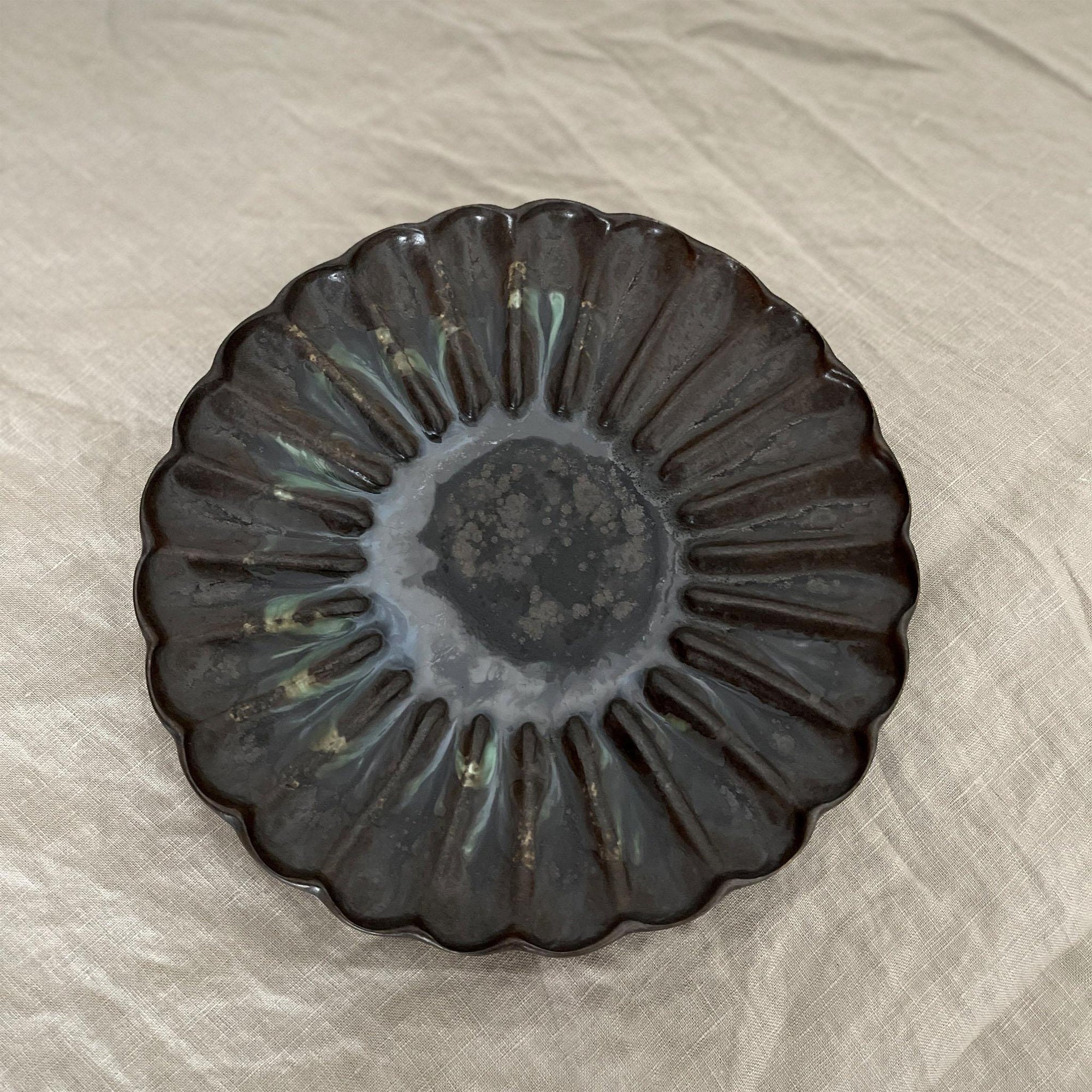Rinka Plate by Yoshida Pottery with nature-inspired design on table setting.