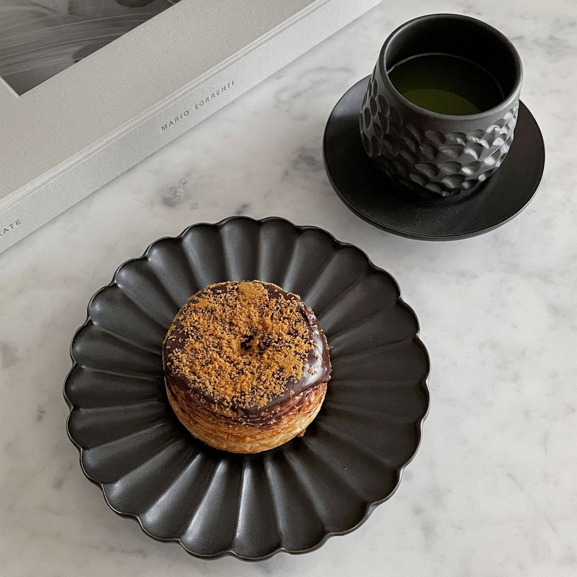 Elegant Rinka Plate by Yoshida Pottery with pastry and cup of green tea on a marble table setting.