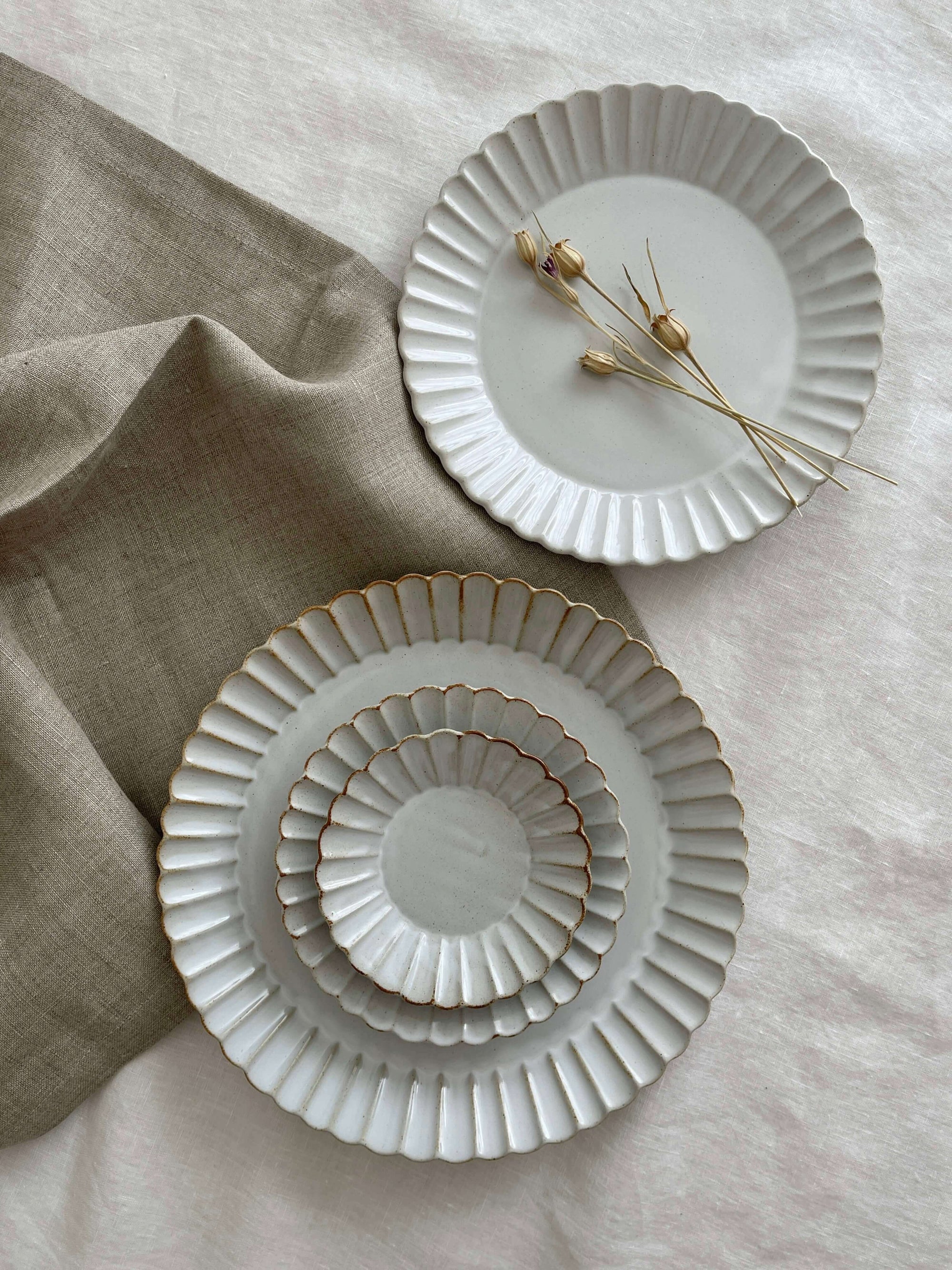 Elegant Marumitsu Barbarie plates with petal-like rim relief displayed on soft linen, perfect for enhancing any dining experience.