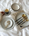 Elegant Barbarie Set with handcrafted Japanese porcelain plates and gold utensils on display, highlighting artistic craftsmanship.
