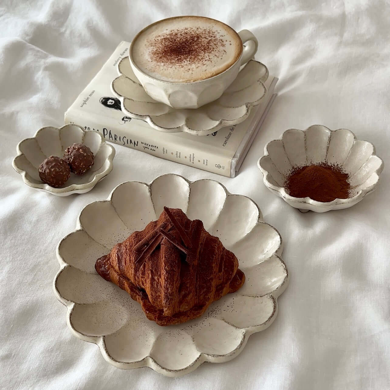 Elegant Rinka Bundle 4 dining set with a croissant on flower petal-shaped plates, showcasing Japanese-Western cultural blend.