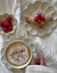 Elegant dining set with flower petal design, featuring coffee, pastry, and raspberries on handcrafted Japanese plates by Kaneko Kohyo.