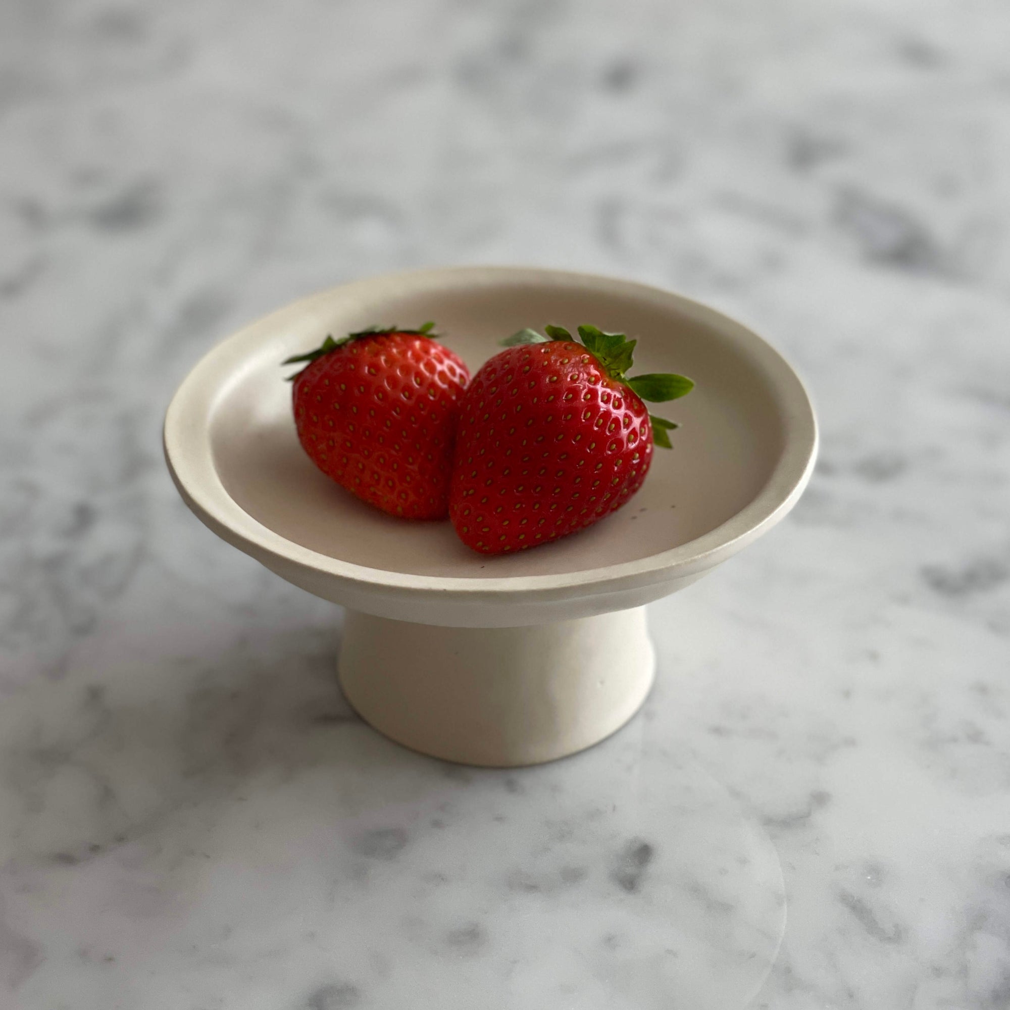 Elegant Yoshida Pottery tall plate with strawberries, nature-inspired design, adds sophistication to any table setting.