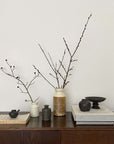 Elegant arrangement of vases with branches on a wooden table, adding a touch of natural beauty and minimalism to the decor.