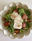 Rinka Bowl 21cm with fresh salad, featuring lettuce, cherry tomatoes, goat cheese, and walnuts, showcasing its flower-shaped porcelain design.