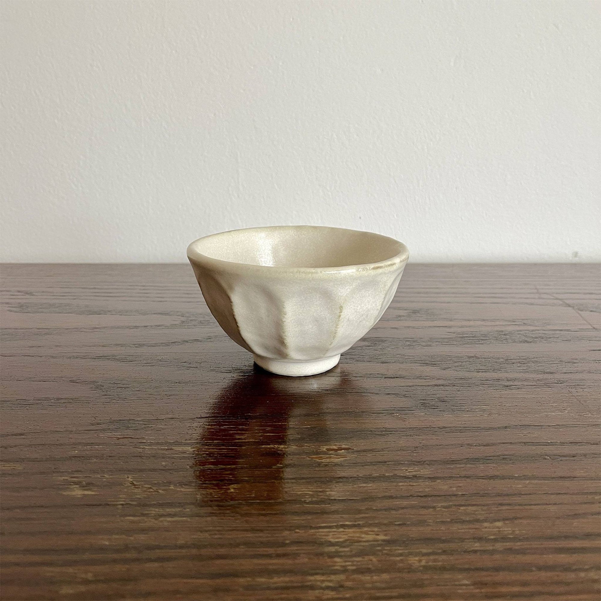 Handmade Rinka small soup bowl with unique glaze texture, 10.5cm, microwave and dishwasher safe, Japanese design on wooden table.