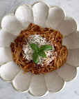 Spaghetti Bolognese served in a flower-shaped Rinka Bowl from Kaneko Kohyo, showcasing delicate porcelain craftsmanship.