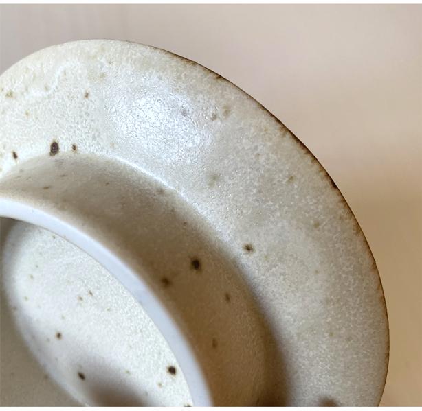 Close-up of the Rila Brown porcelain plate by Kaneko Kohyo, featuring a textured matte surface with a warm color.