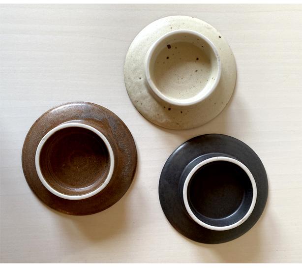 Top view of three Kaneko Kohyo porcelain bowls, featuring different textured matte finishes in black, brown, and cream.