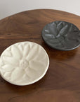 Elegant black and white Mame Plate set from Yoshida Pottery Collection on a wooden table, showcasing nature-inspired patterns.