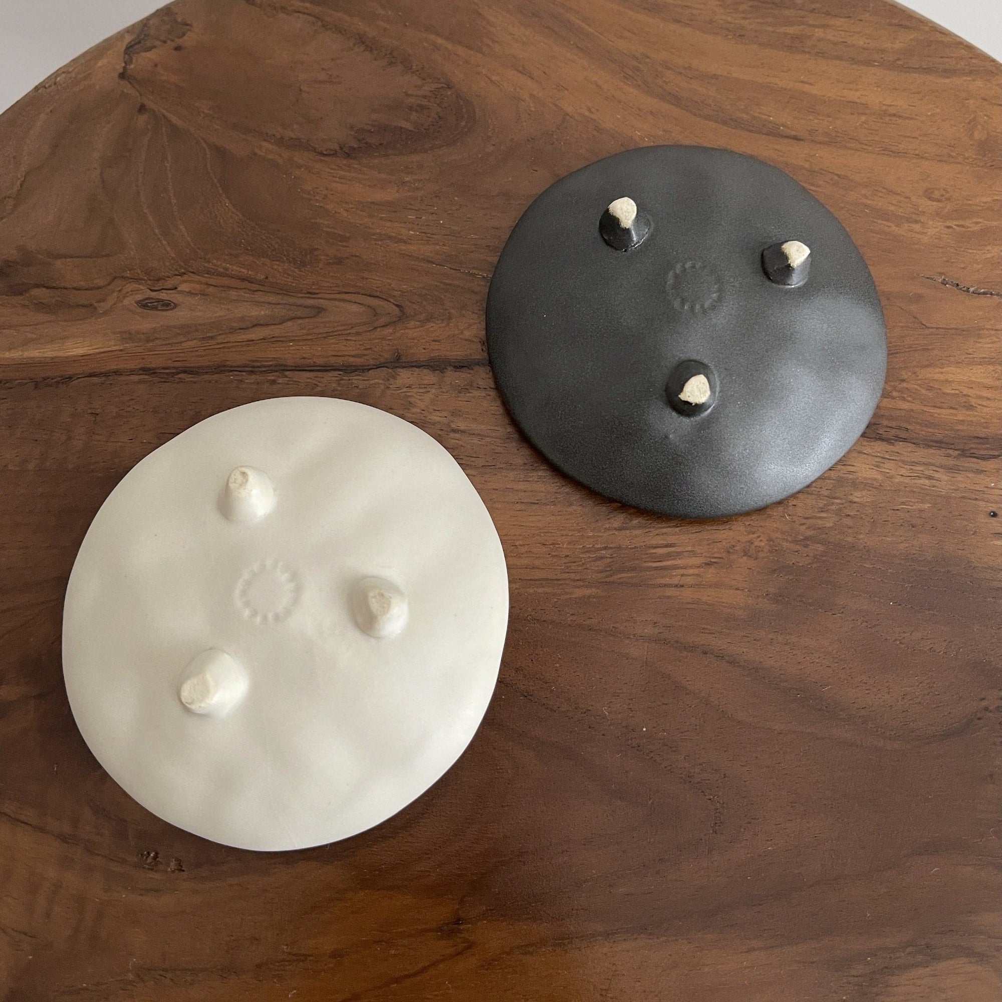 Elegant black and white Mame Plate Set by Masakazu Yoshida, infused with nature-inspired patterns, on a wooden table.