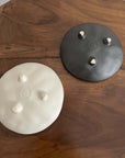 Elegant black and white Mame Plate Set by Masakazu Yoshida, infused with nature-inspired patterns, on a wooden table.