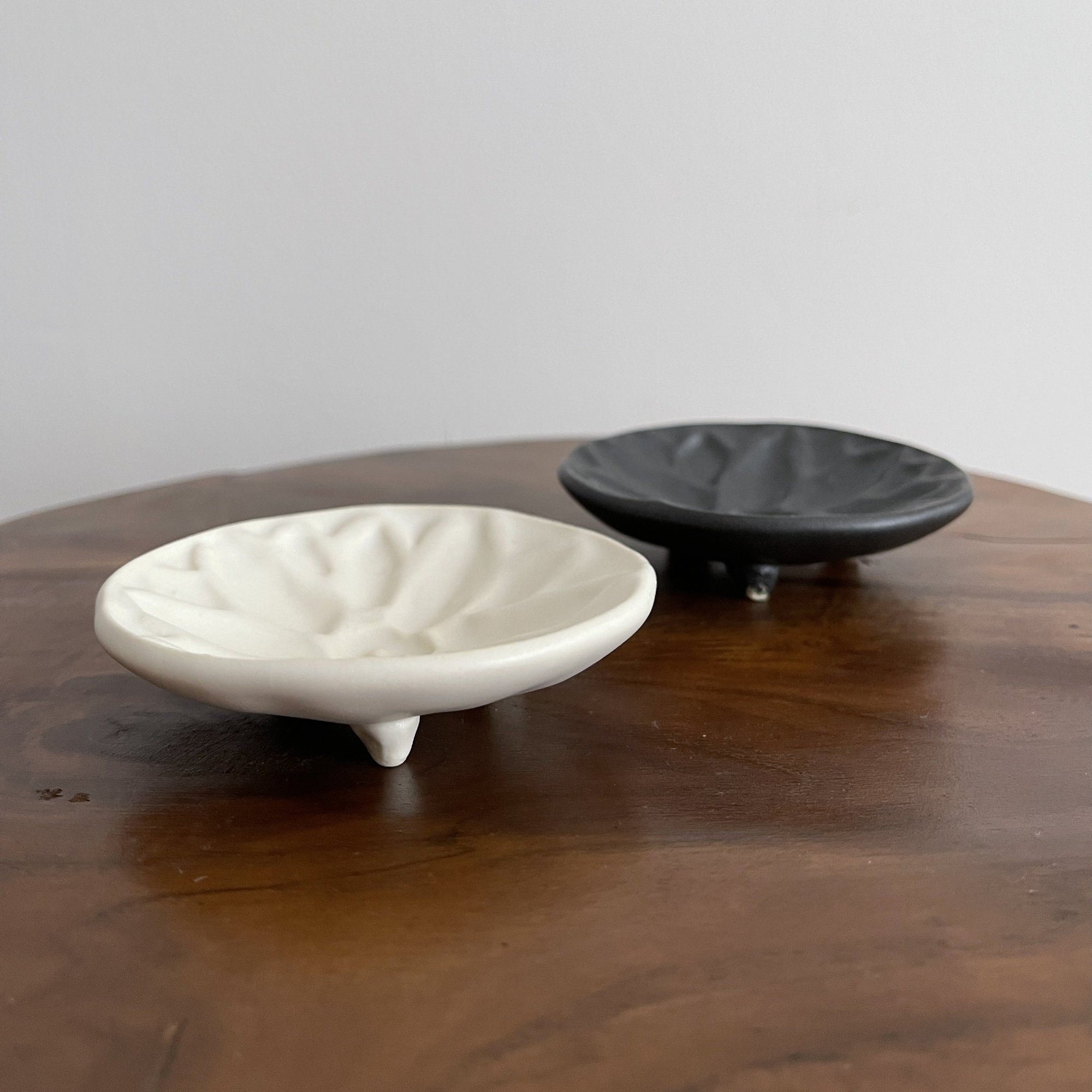 Mame Plate Elegant Black & Innocent White Set from Yoshida Pottery, showcasing nature-inspired design on a wooden table.