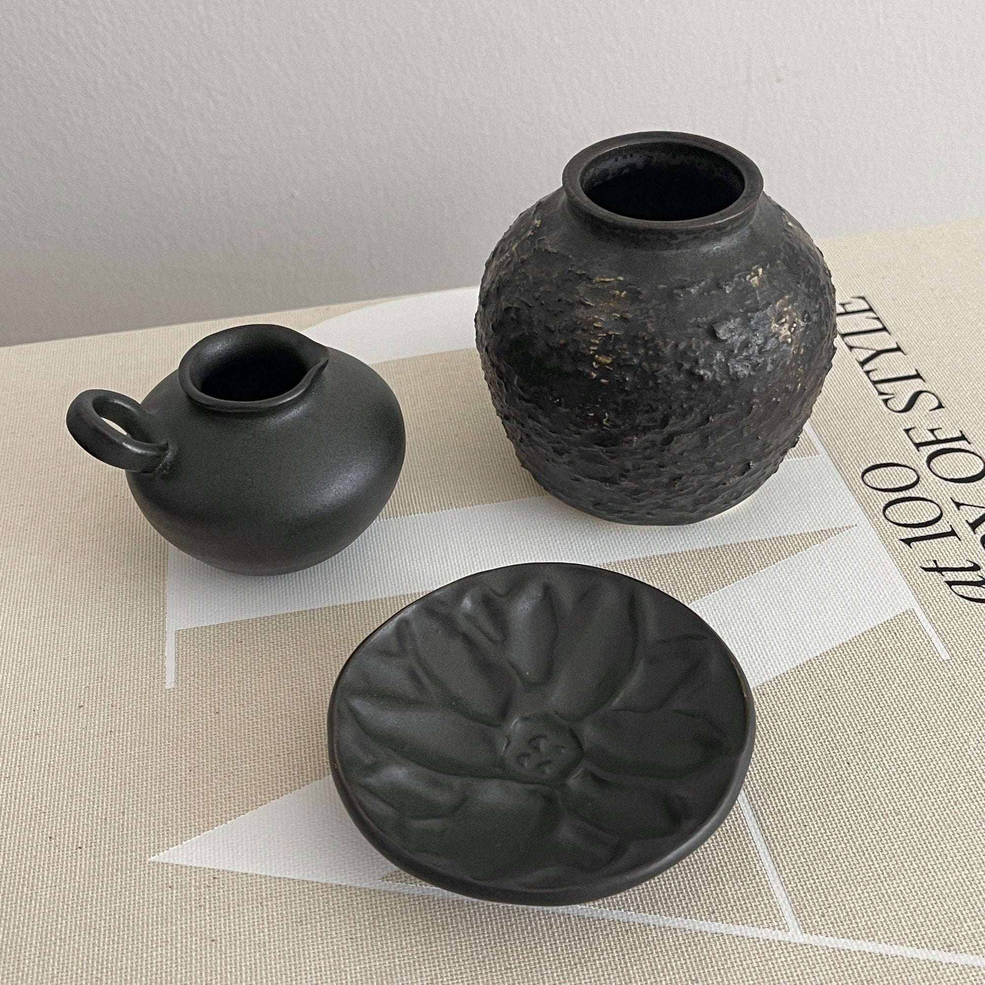 Elegant black pottery set with nature-inspired patterns from Yoshida Pottery Collection by Masakazu Yoshida.