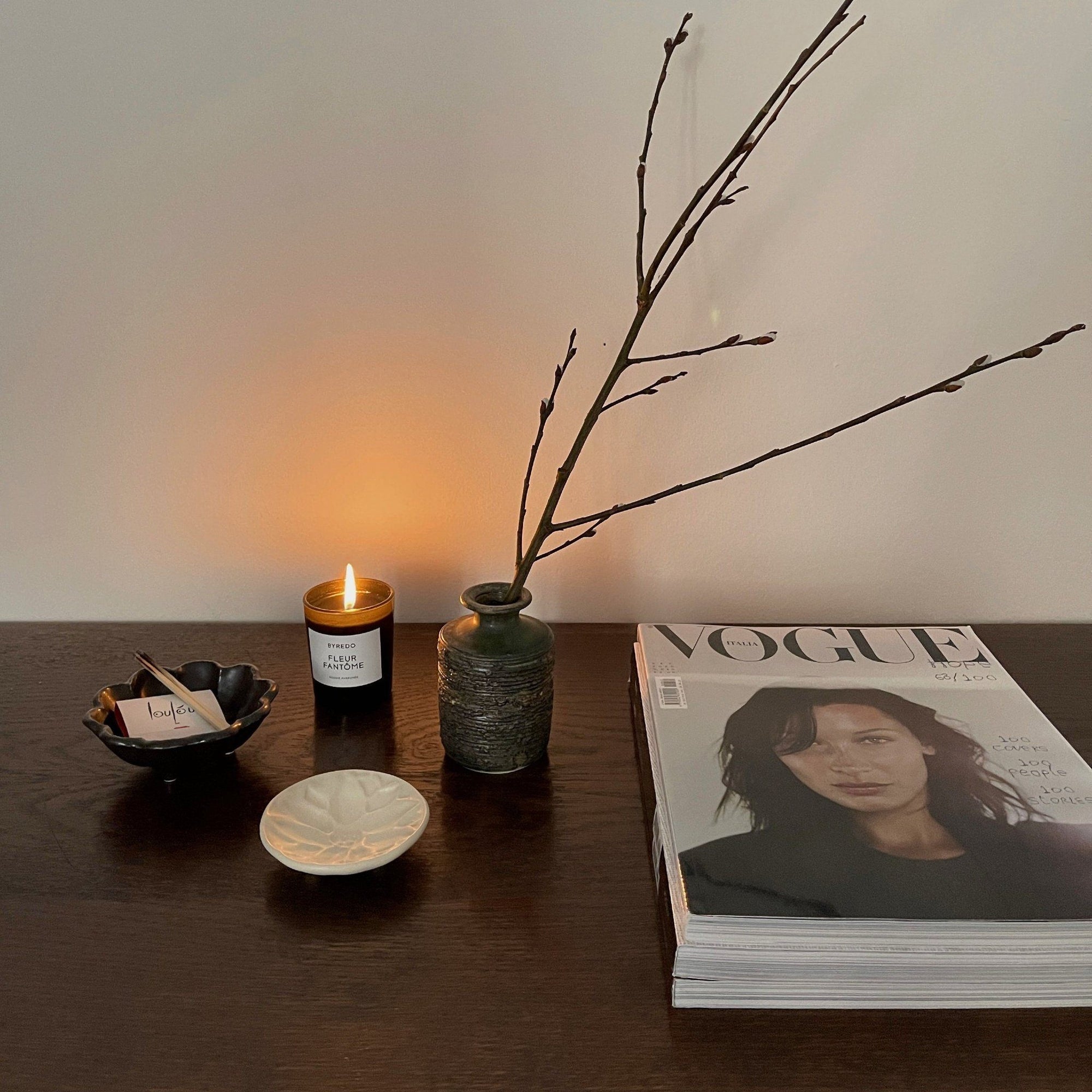 Elegant table setting with a Mame Plate set, candle, vase, and magazine creating a cozy and stylish ambiance.