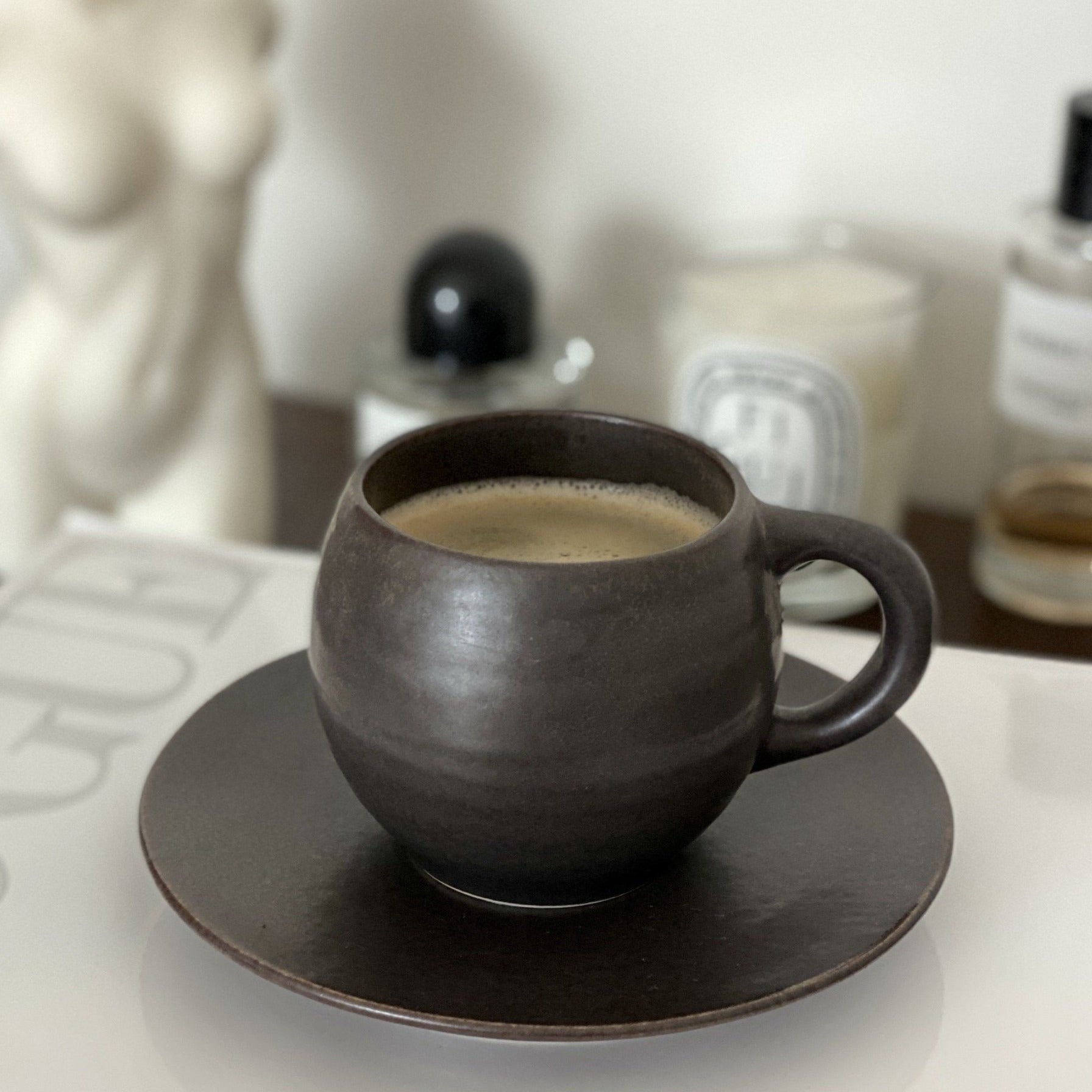 Rila Black Mug on saucer, textured porcelain, microwave-safe, Kaneko Kohyo design, matte finish, 340ml capacity, stylish setting.