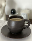 Rila Black Mug on saucer, textured porcelain, microwave-safe, Kaneko Kohyo design, matte finish, 340ml capacity, stylish setting.